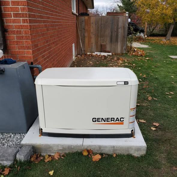 Generac standby generator installed on a concrete pad beside a brick home